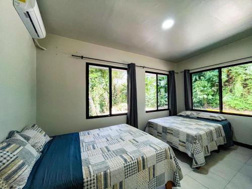 Quebrada GanadoSelva Pacific Mountain Beach retreat的一间卧室设有两张床和两个窗户。