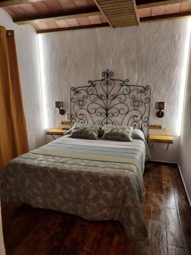 卡斯特里尔Casa Rural Miravella的一间卧室配有一张大床和金属床头板