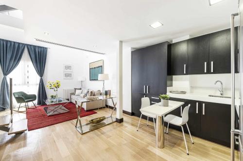 马德里Luxury duplex close to Gran Via Colon的厨房以及带桌椅的起居室。
