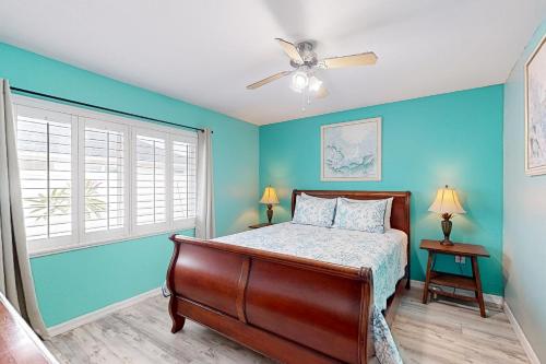 威尼斯Gulf Coast Dreaming的一间卧室设有蓝色的墙壁、一张床和吊扇。