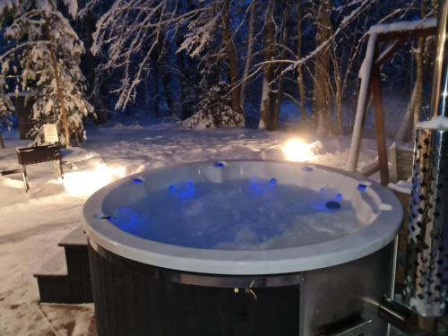 IkšķileToma pirts BRĪVDIENU的晚上在雪地里设有一个按摩浴缸