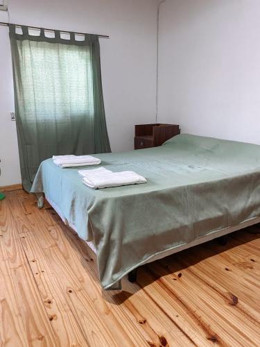 乌拉圭河畔康塞普西翁Los colibríes的一间卧室配有一张床,上面有两条毛巾