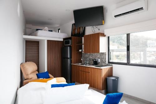 巴亚尔塔港Monyxbnb Hotel的一间带白色沙发的客厅和一间厨房