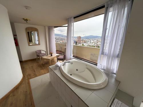 基多斯坦福套房酒店的窗户前设有浴缸的大浴室
