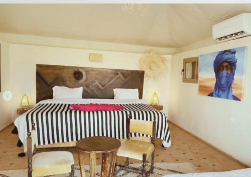 Aït DaoudThe Original Camp的一间卧室配有一张大床和一张桌子及椅子