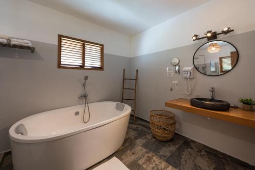 拉斯特拉纳斯TAKUMA BOUTIK HOTEL的浴室配有大型白色浴缸和水槽