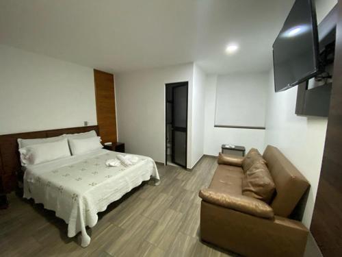 波哥大Hotel Yolima Real的酒店客房,配有床和沙发