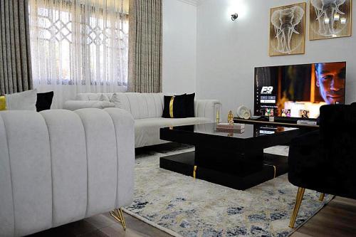 基苏木3 BDR Luxurious Villa in Milimani Kisumu的客厅配有白色沙发和电视