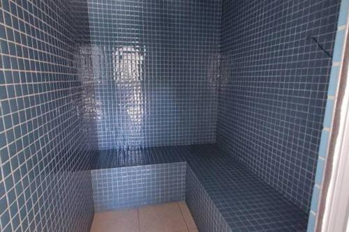 萨尔瓦多Apto novo, pratico, otimo para trabalhar e lazer .的蓝色瓷砖浴室设有蓝色瓷砖淋浴