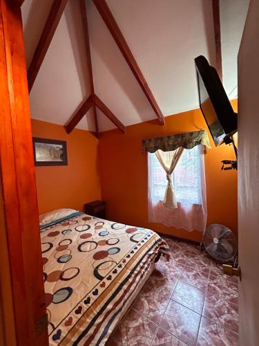 Monte GrandeCABAÑAS RINCON CHILENO的一间拥有橙色墙壁的卧室和一张位于客房内的床