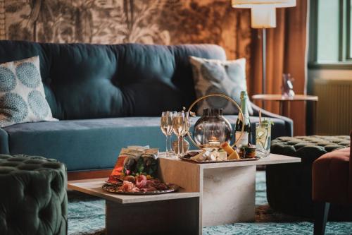 Bro乐杰达斯洛特酒店的客厅配有带酒杯的桌子和沙发