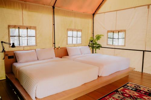 TangkubanperahuLuxury Deck Cabin的带2扇窗户的客房内的2张床