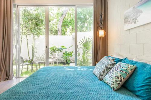 图卢姆Casa Cuatro Vientos的卧室内的一张带蓝色床单和枕头的床