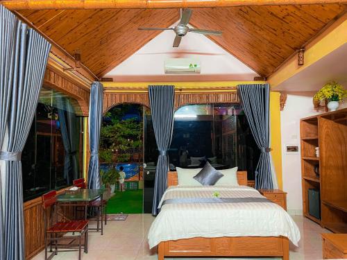 Vũ LâmTAM COC SUNRISE HOMESTAY (VÂN VIỄN, đội 2)的一间卧室配有一张床、一张桌子和一个窗户。
