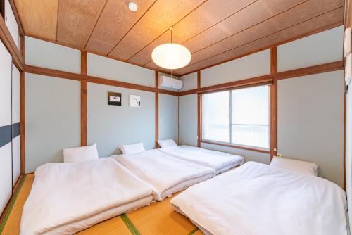东京GuestHouse　YOU&I平和島的配有木天花板的客房设有两张床。