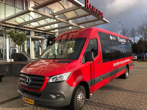 巴德胡弗多普Ramada by Wyndham Amsterdam Airport Schiphol的停在大楼前的一辆红色和黑色货车