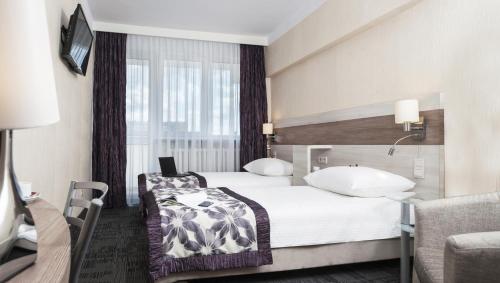 比亚韦斯托克三重奏舒适酒店的一间酒店客房,设有两张床和电视