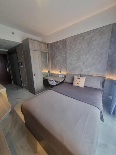 TjilandakMashley Room Prestige Apartment SKY HOUSE BSD的一间卧室配有一张大床和一把椅子