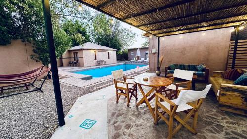 圣佩德罗·德·阿塔卡马Ickota B&B的一个带桌椅的庭院和一个游泳池