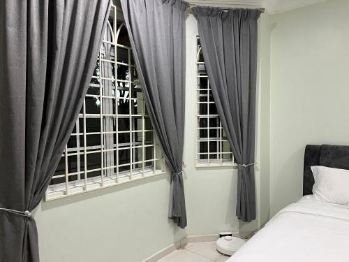 MerlimauMutiara Villa Homestay - Comfort Away From Home的卧室配有灰色窗帘、床和窗户