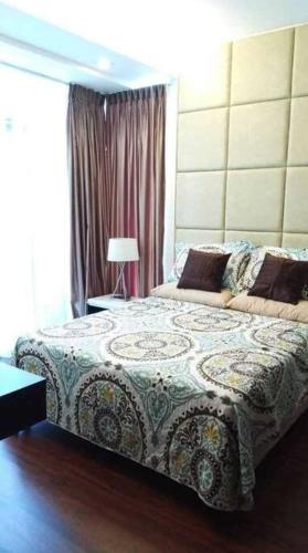 马尼拉The Pearl - BGC Blue Sapphire 1BR的一间卧室设有一张床和一个窗口