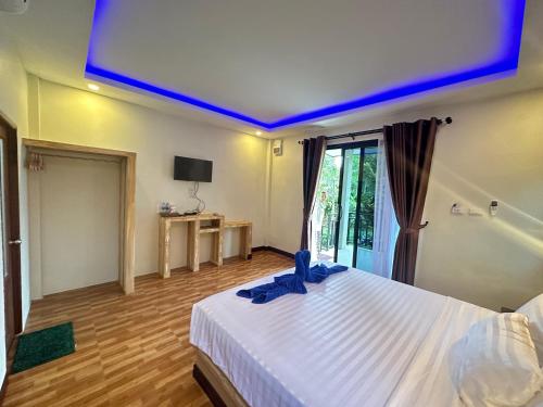 高兰Lanta Living bungalow的一间卧室配有白色的床,上面有蓝色的灯光