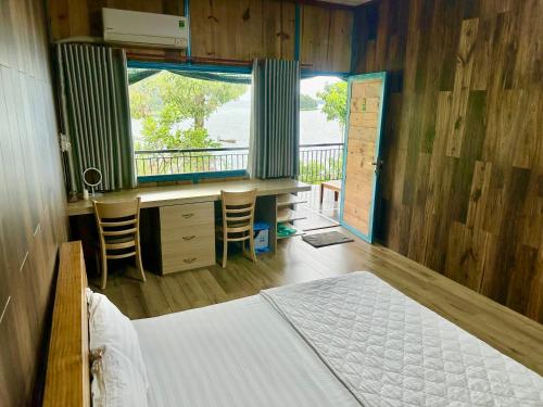 Xã Gia TânBến Hồ Homestay的一间卧室配有一张床、一张书桌和一个窗户。