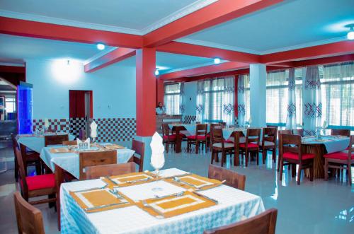 布琼布拉Kinindo Light Hotel的用餐室设有桌椅和窗户。