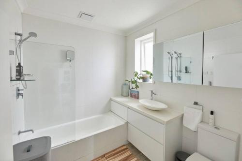 悉尼Tamarama Beachfront Apartment on Bondi to Bronte Walk的白色的浴室设有水槽和镜子