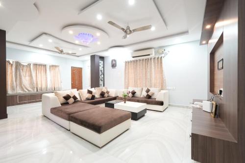 蒂鲁帕蒂Paradise villas - duplex 5bhk - A Golden Group Of Premium Home Stays - tirupati的客厅配有沙发和桌子