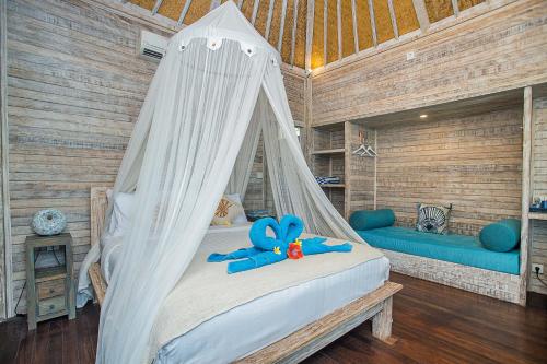 蓝梦岛Nusa View的一间卧室,配有一张带蓝色泰迪熊的床