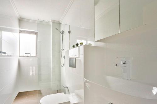 悉尼Superb 3 Bedroom Apartment Surry Hills的白色的浴室设有卫生间和淋浴。