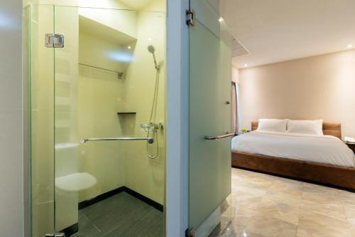 曼谷Sukhothai Hotel and Residence的带淋浴的浴室和客房内的一张床