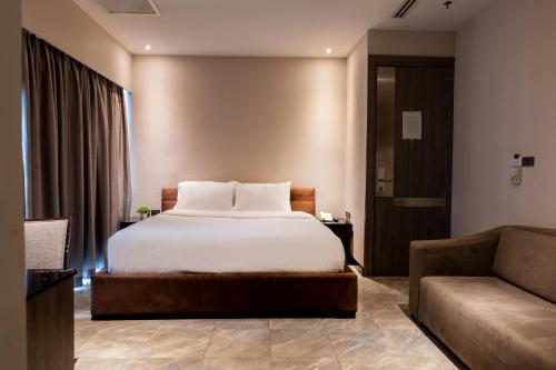 曼谷Sukhothai Hotel and Residence的酒店客房,配有床和沙发
