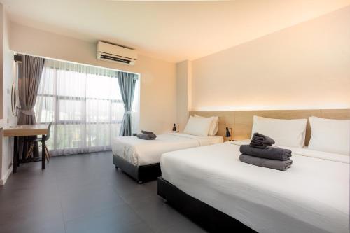 清迈依思迪酒店-SHA Extra Plus的酒店客房设有两张床和窗户。