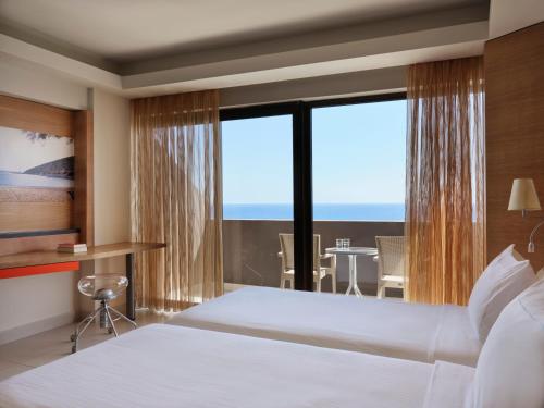 法里拉基Esperos Mare Resort的酒店客房设有一张床和一个大窗户