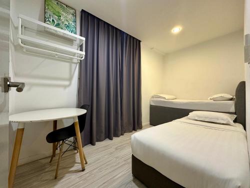 哥打京那巴鲁Utopian Homes at Sutera Avenue的客房设有两张床、一张桌子和一扇窗户。
