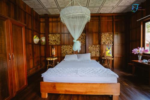 Ấp Nhơn BìnhMuong Dinh Lodge的一间卧室配有一张床和一个吊灯