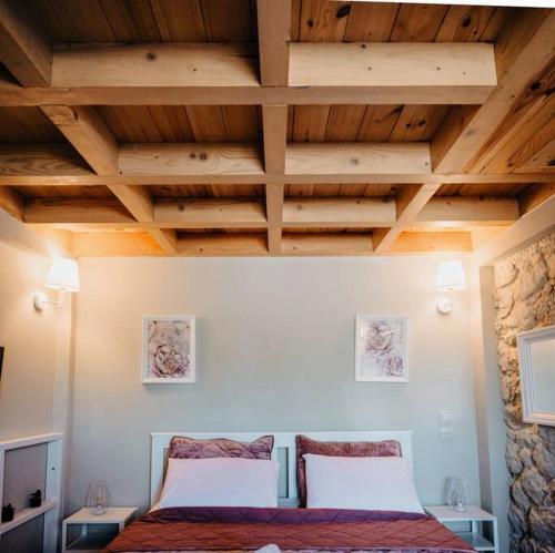Villa Pialia的一间卧室设有一张床和木制天花板