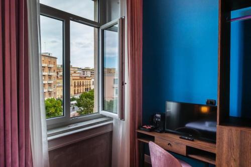 福贾Momento Soggiorno di Charme的客房设有电视和美景窗户。