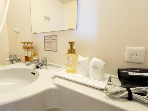仙台仙台城堡经济型酒店的浴室柜台配有水槽和洗浴用品。