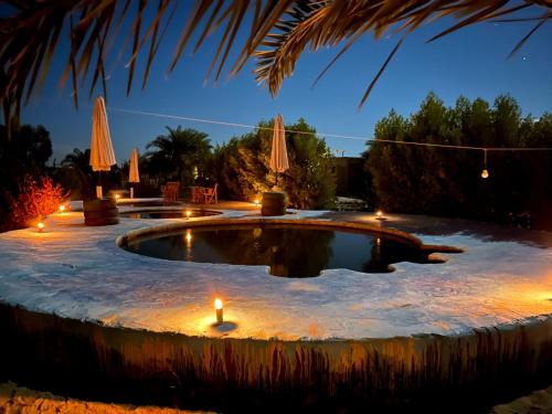 锡瓦Santarya hotel的夜间雪地里放着蜡烛的游泳池