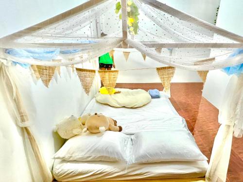 曼谷Getaway Villa Bangkok - 4 Bedroom,6 Beds and 5 Bathroom的两只泰迪熊躺在天篷床上