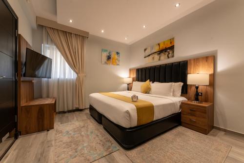 吉达Andalus Habitat Hotel的一间卧室配有一张大床和一台平面电视