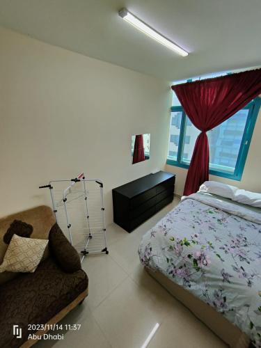 阿布扎比Bedroom 4的卧室配有床、椅子和窗户。