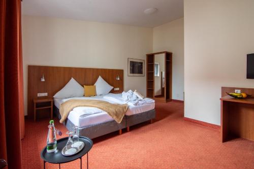 Das kleine Amtshotel的酒店客房配有一张床铺和一张桌子。