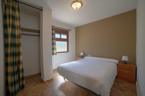 阿尔卡拉德尔胡卡尔Apartamentos Berrocal的卧室配有白色的床和窗户。