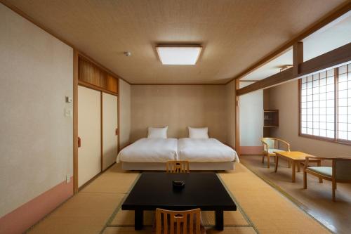 上川町層雲閣的一间卧室配有一张床和一张桌子