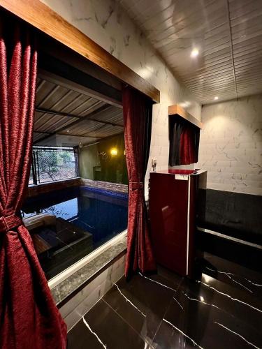 罗纳瓦拉MOUNT BUNGALOWS-1 BEDROOM Private pool chalet -wifi -private pool-ac的室内的游泳池,红色窗帘