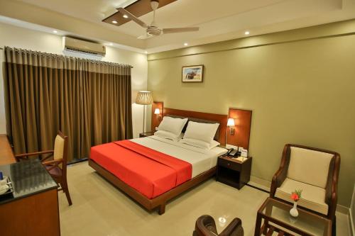 PallipuramHarbour Hotels的酒店客房,配有一张床、一张桌子和椅子